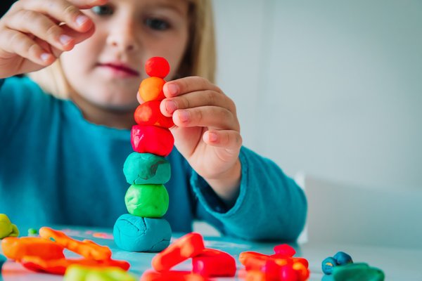Little girl playing with clay molding shapes, kids crafts