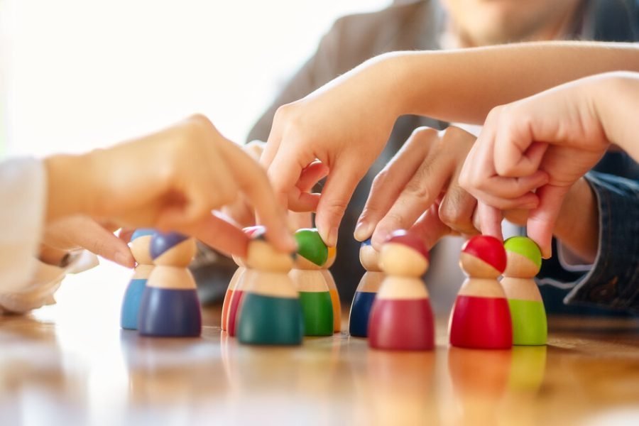 People choosing and picking up wooden figure from a group on the